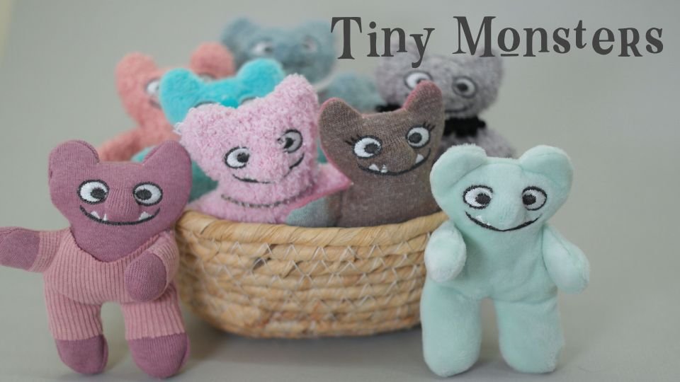 several tiny plushie monsters in a basket