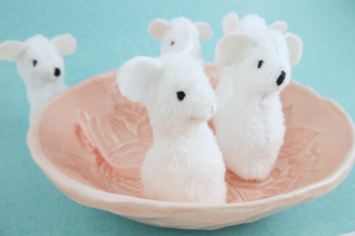 little white fabric mice in a pink ceramic bowl